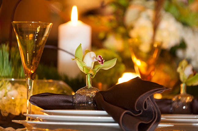 Vela, taça, flores e itens complementares para mesa