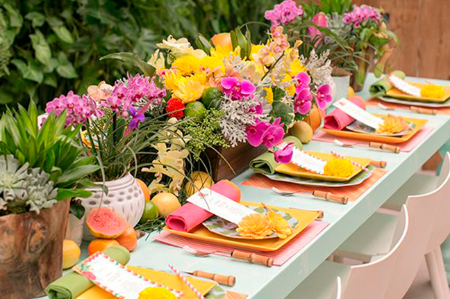 mesa posta decorada com flores rosas e amarelas