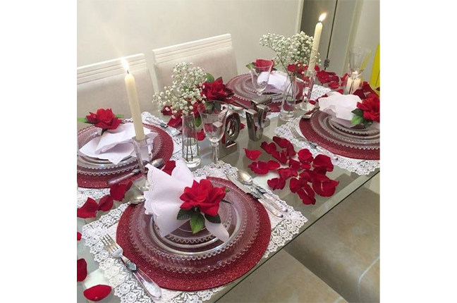 decoração de mesa vermelha com pétalas de rosa
