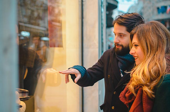 casal vendo vitrine de loja